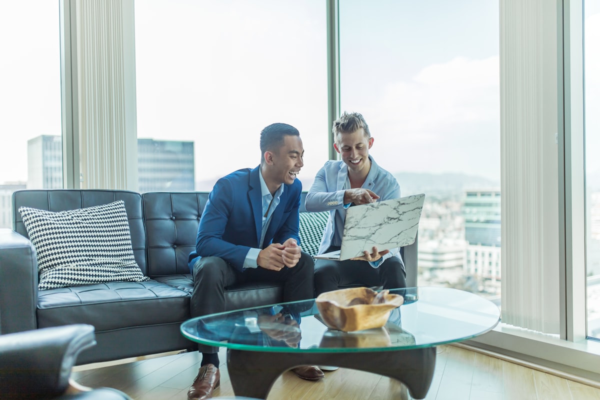 Un agent immobilier échange avec des clients dans un appartement moderne.